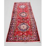 A large red ground Persian Tabriz runner, with unique starburst medallion design, 335cm x 127cm