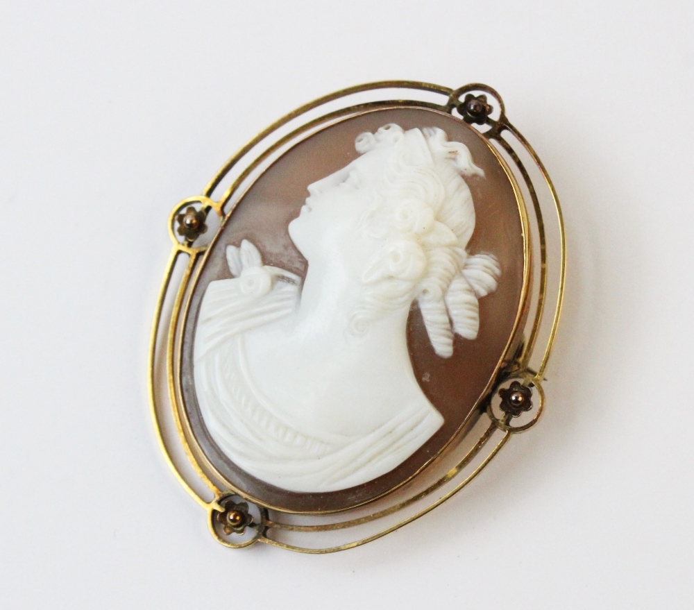 A Victorian carved shell cameo brooch, the central oval cameo depicting the profile of a woman