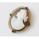 A Victorian carved shell cameo brooch, the central oval cameo depicting the profile of a woman