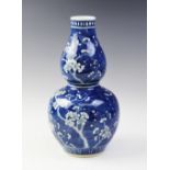 A Chinese porcelain blue and white prunus pattern gourd vase, Kangxi four character mark (late