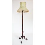 A George III style mahogany standard lamp, 20th century, the ring turned gun barrel column raised