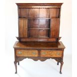 An 18th century and later oak Welsh dresser, the moulded cornice above a wavy frieze and three