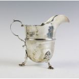 A Victorian silver cream jug by Stokes & Ireland, London 1897, with shaped rim and scrolling