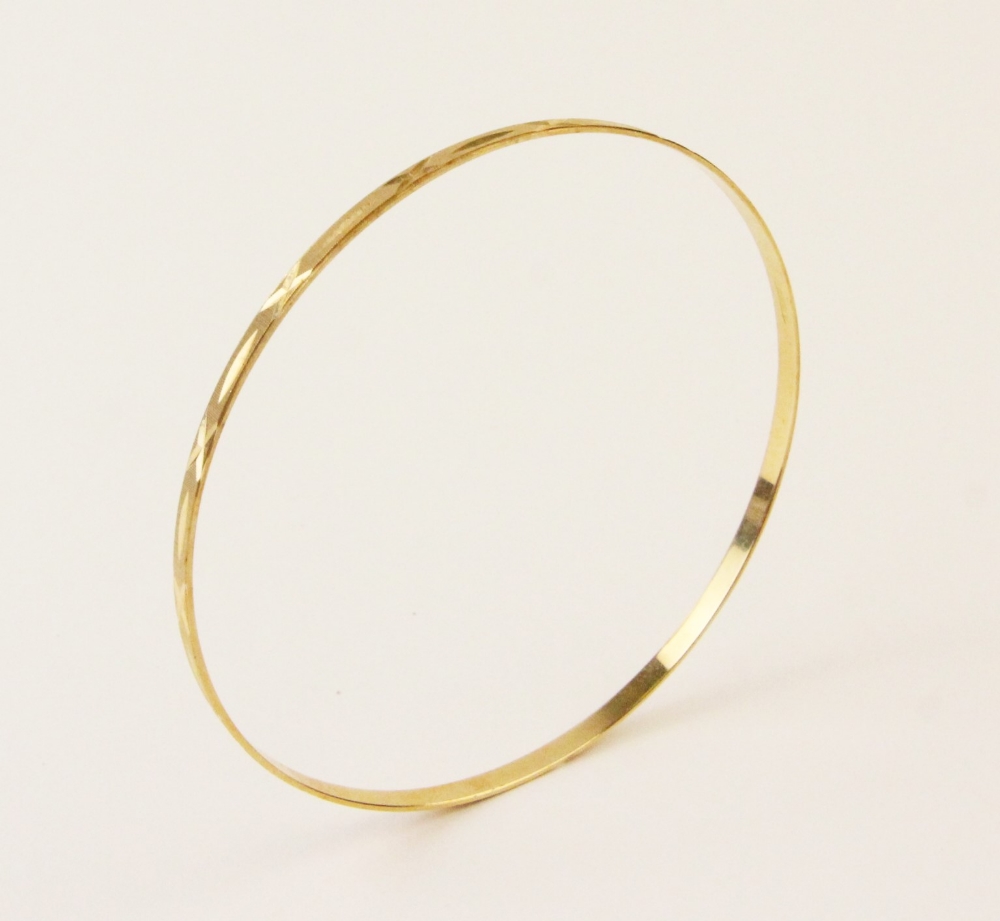 An 18ct yellow gold bangle, the round bangle with engine turned decoration to exterior, lozenge - Bild 3 aus 5