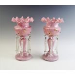 A pair of Victorian pink glass lustres, each of baluster form, with a wavy rim and applied gilt