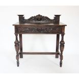 A late Victorian oak green man side table, the galleried back centred with a carved green man