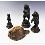 Three graduated Black Forest carvings of bears, each modelled standing upon a turned integral