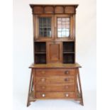 A Glasgow school Arts and Crafts oak cabinet on chest, circa 1900, the hinged flat top and frieze