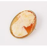 A carved shell cameo brooch pendant, the oval cameo depicting a woman in classical Greek attire, set