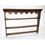 A George III style oak dresser rack, with a moulded dentil cornice above a shaped frieze and three