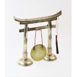 A large white metal Chinese dinner gong, modelled as a paifang suspending a polished brass plate,