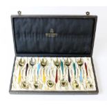 A set of twelve Norwegian silver gilt enamelled teaspoons by David Andersen, each with enamelled