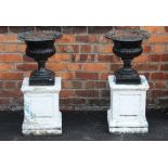 A pair of painted Victorian cast iron garden urns, of lobed bowl form with a cast scalloped rim,