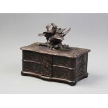 An early 20th century carved oak black forest jewellery box, the serpentine hinged lid surmounted