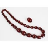 A cherry amber necklace, comprising thirty three polished oval cherry amber beads measuring