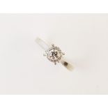 A diamond cluster ring, comprising a round mixed cut diamond weighing and approx. 0.25 carat (