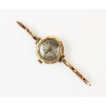 A lady?s 9ct gold vintage wristwatch, the silvered dial with engine turned decoration and roman