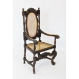 A Victorian carolean style carved walnut throne chair, the profusely carved scrolling leafy frame