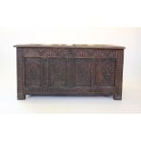 A late 17th century oak coffer, the four panel lid above a lunette carved frieze, and four panels