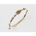 A Victorian diamond and ruby set bangle, the central panel set with a small mixed cut ruby and two