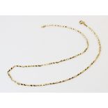 A yellow metal necklace chain, comprising alternating sections of faceted links and cable links,