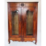 An 18th century and later French cherry wood display cabinet, the frieze centred with a carved