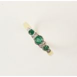 An emerald and diamond 18ct yellow gold ring, comprising three round mixed cut emeralds measuring