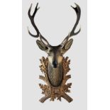 A large carved wood and painted stags head, mid-20th century, realistically carved with glass eyes