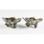 A pair of silver plated shell shaped salts, possibly Elkington & Co, one stamped 'GS', each 11.8cm