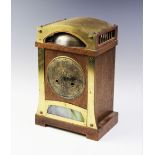 An Arts and Crafts oak and brass mounted mantel clock for Liberty & Co by H.A.C, the arched oak case