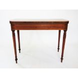 A George III mahogany folding games table, the rosewood cross banded top enclosing a baize lined