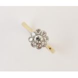 A diamond floral cluster ring, comprising a central round brilliant cut diamond weighing approx. 0.