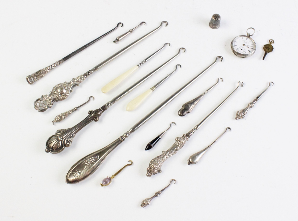 A selection of Victorian and later silver and white metal button hooks, assorted makers, sizes and