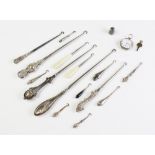 A selection of Victorian and later silver and white metal button hooks, assorted makers, sizes and