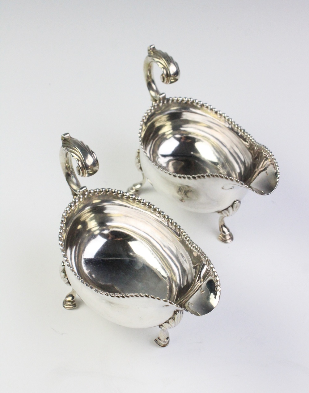 A pair of George III silver sauce boats, each of oval form with leaf-capped scroll handle, punch - Image 2 of 3