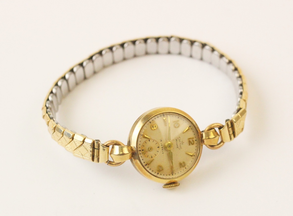 A lady's 9ct gold Smith's Deluxe vintage wristwatch, the round cream dial with Arabic numerals and