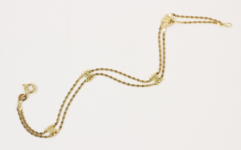 An 18ct gold bracelet, comprising two scroll link chains with four cross-link spacers, spring ring