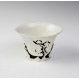 A Chinese blanc de chine porcelain libation cup, of typical form, with reticulated base and