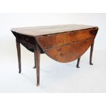 An early 18th century oval oak drop leaf dining table, the plank top above a single frieze drawer,