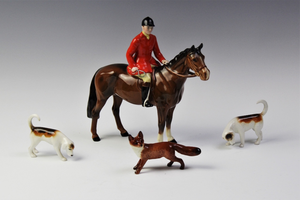 A Beswick huntsman on horseback, two hounds and a standing fox, the huntsman on a bay horse, model