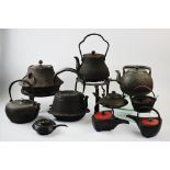 A collection of Japanese Tetsubin kettles, to include, a pair with red lacquered lids, 13cm high,