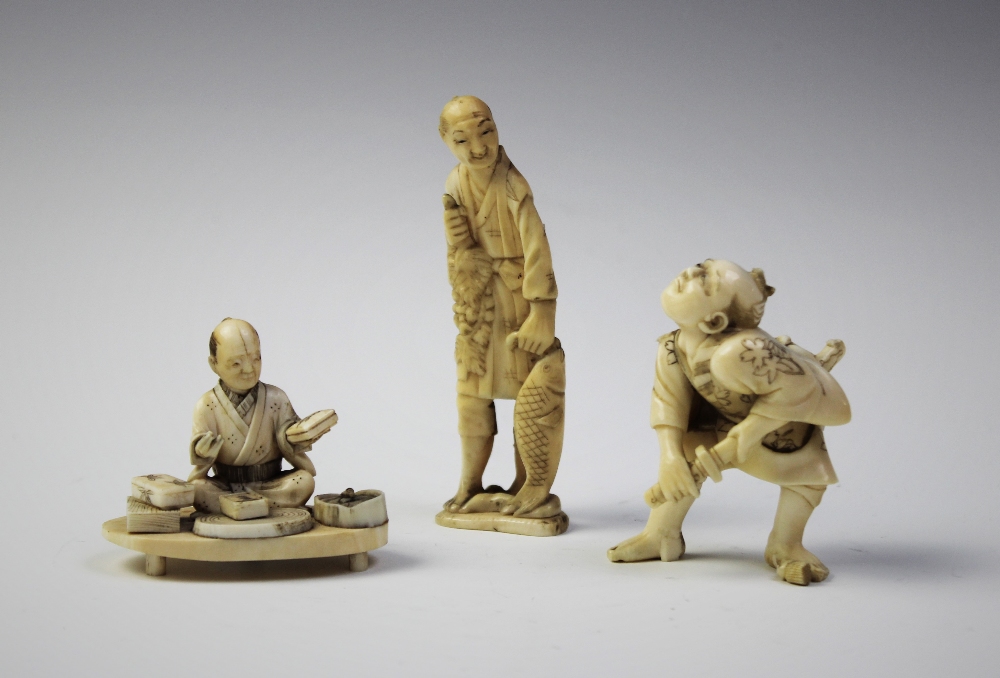 A Japanese carved ivory okimono, Meiji period (1868 - 1912), modelled as a woodblock printer, 4cm