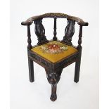 A Victorian carved oak corner chair, the bow shaped top rail centred with a carved green man mask,