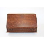 An early 20th century oak stacking bureau, the fall front enclosing a compartmentalised interior,