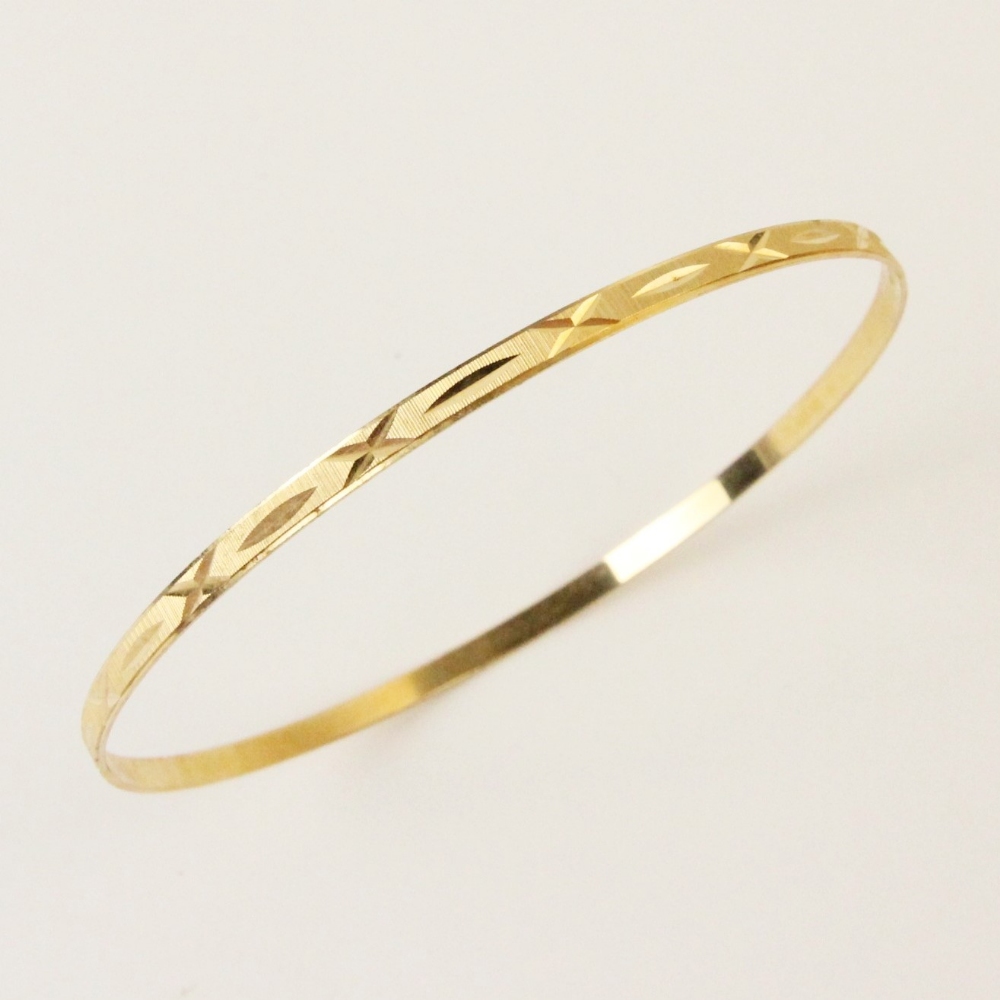 An 18ct yellow gold bangle, the round bangle with engine turned decoration to exterior, lozenge