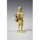 A Japanese carved ivory okimono, Meiji period (1868 - 1912), designed as a fisherman feeding a bird,