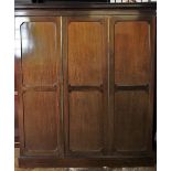 An Edwardian mahogany two door wardrobe, the cavetto cornice above two outer invert panelled doors