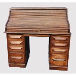 An oak early 20th century oak roll top desk, the 'S' shaped tambour front enclosing a