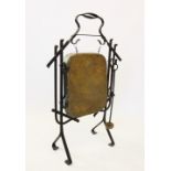 An early 20th century Arts & Crafts style wrought iron and brass dinner gong, the rectangular dished
