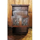 An early 20th century oak Art Nouveau wall hanging cabinet, with a recessed shelf above a cupboard